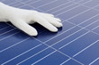 Hand mit weissem Handschuh vor Solarzellen