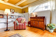Living room with red chair and gold ceiling and walls.