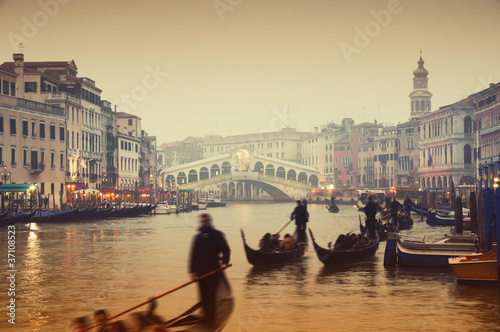 Photo: Rialto Bridge and gondolas at a foggy autumn evening in Venice. Rialto Bridge and gondolas at a foggy autumn evening in Venice.