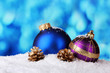 beautiful blue and purple Christmas balls and cones in snow beautiful blue and purple Christmas balls and cones in snow