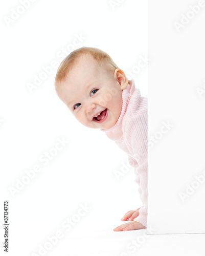 Photo: funny smiling girl look out of wall funny smiling girl look out of wall
