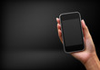 Photo: Mobile phone in woman hand on black background Mobile phone in woman hand on black background