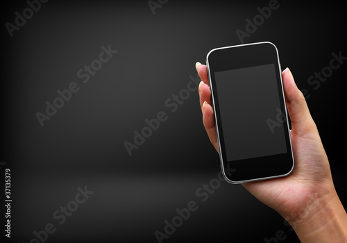 Photo: Mobile phone in woman hand on black background Mobile phone in woman hand on black background