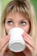The young woman drinks from a mug The young woman drinks from a mug