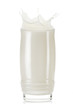 Glass of milk with splash and drops on white background