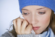 A woman crying, wiping her tears away with a tissue
