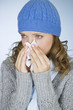 A young woman blowing her nose