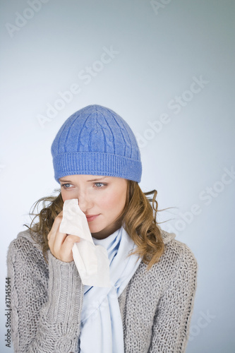 Photo: A young woman wiping her tears away with a tissue A young woman wiping her tears away with a tissue
