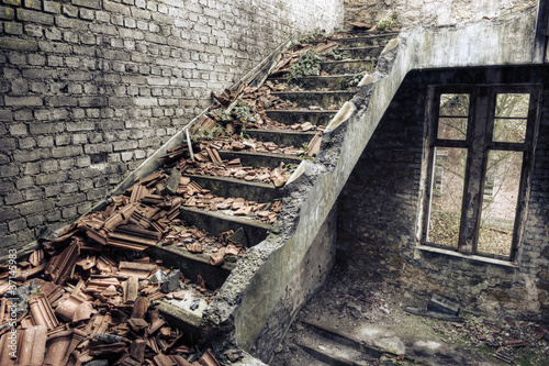Foto: Collapsed roof tiles on a staircase in a derelict building Collapsed roof tiles on a staircase in a derelict building