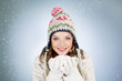 A young woman holding a handful of snow, smiling