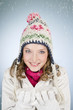 A young woman holding a handful of snow, smiling
