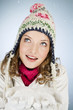 A young woman holding a handful of snow, smiling