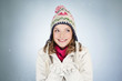 A young woman holding a handful of snow, smiling