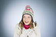A young woman holding a handful of snow, laughing