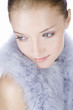 Portrait of a young woman wearing a feather shrug, looking away
