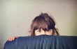 Photo: Little girl playing hide and seek behind the sofa Little girl playing hide and seek behind the sofa