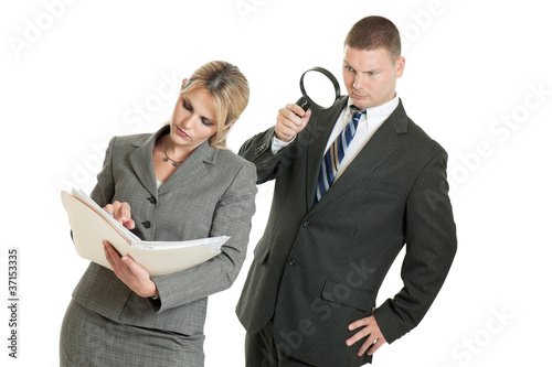 Photo: Business man spying on business woman with magnifying glass Business man spying on business woman with magnifying glass