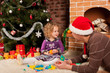 Little girl play with her dad  near Christmas tree