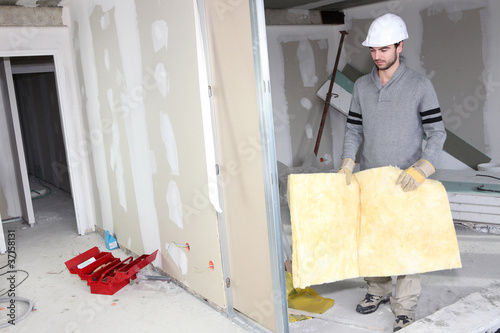 Photo: Builder carrying wall insulation Builder carrying wall insulation