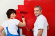 Married couple painting wall