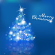 Christmas tree with blurred lights on blue background.