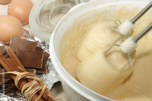 Photo: Cake ingredients in bowl with electric mixer next to it Cake ingredients in bowl with electric mixer next to it
