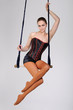 Young woman on trapeze, on white background.