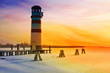 Lighthouse at the sunset on the frozen lake Lighthouse at the sunset on the frozen lake