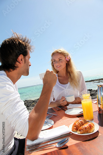 Foto: Couple having breakfast by blue lagoon Couple having breakfast by blue lagoon