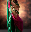 Beautiful exotic belly dancer woman a rot-green costume