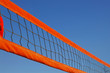 Beach volleyball net against a clear blue sky