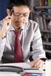 Photo: businessman using pen touch his head showing thinking of work. businessman using pen touch his head showing thinking of work.