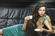 young elegant girl in green with cup, she is lying on the sofa young elegant girl in green with cup, she is lying on the sofa