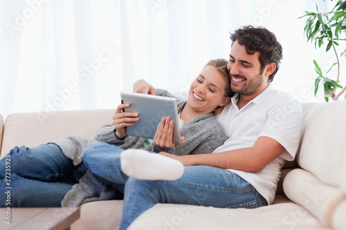 Foto: In love couple using a tablet computer In love couple using a tablet computer