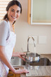 Portrait of a woman pouring water in a sauce pan