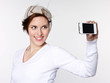 Smiling girl takes a self-photograph with smart phone