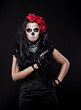 Photo: Serious woman in day of the dead mask with gun Serious woman in day of the dead mask with gun