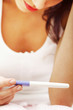 Worried woman looking at a pregnancy test.
