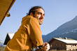 jeune homme souriant en chalet de montagne au soleil