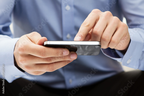 Photo: Young adult using a smart phone Young adult using a smart phone