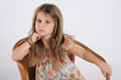 Little cute girl with long hair sitting on the chair