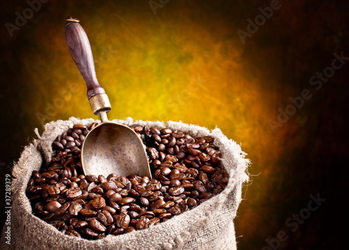 Photo: Sack of coffee beans and scoop. On a dark background. Sack of coffee beans and scoop. On a dark background.