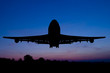Silhouette of the plane starting on a sunset background.