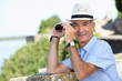 senior gentleman admiring view with binoculars