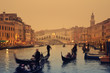 Rialto Bridge and gondolas at a foggy autumn evening in Venice.