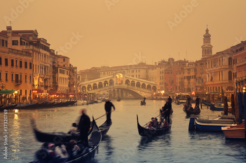 Photo: Rialto Bridge and gondolas at a foggy autumn evening in Venice. Rialto Bridge and gondolas at a foggy autumn evening in Venice.