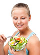 Young woman eating vegetable salad isolated on white