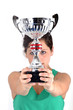 Foto: Trophée - Coupe tenue par une jeune sportive Trophée - Coupe tenue par une jeune sportive