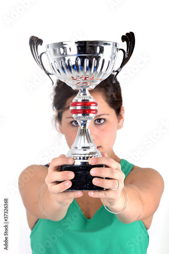Foto: Trophée - Coupe tenue par une jeune sportive Trophée - Coupe tenue par une jeune sportive
