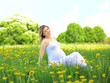pregnant woman sitting on meadow pregnant woman sitting on meadow
